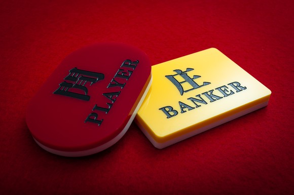 Baccarat chips on a red background.