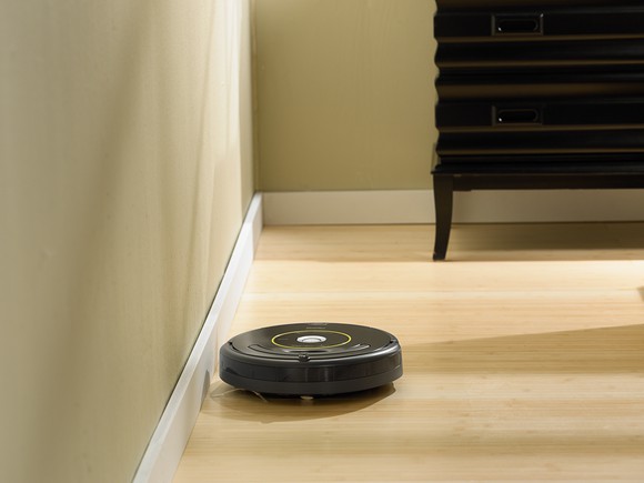 The iRobot Roomba 650 self-piloting vacuum cleaner cleaning a wood floor.