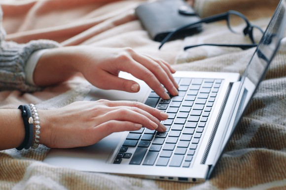 Pair of hands types on a laptop.