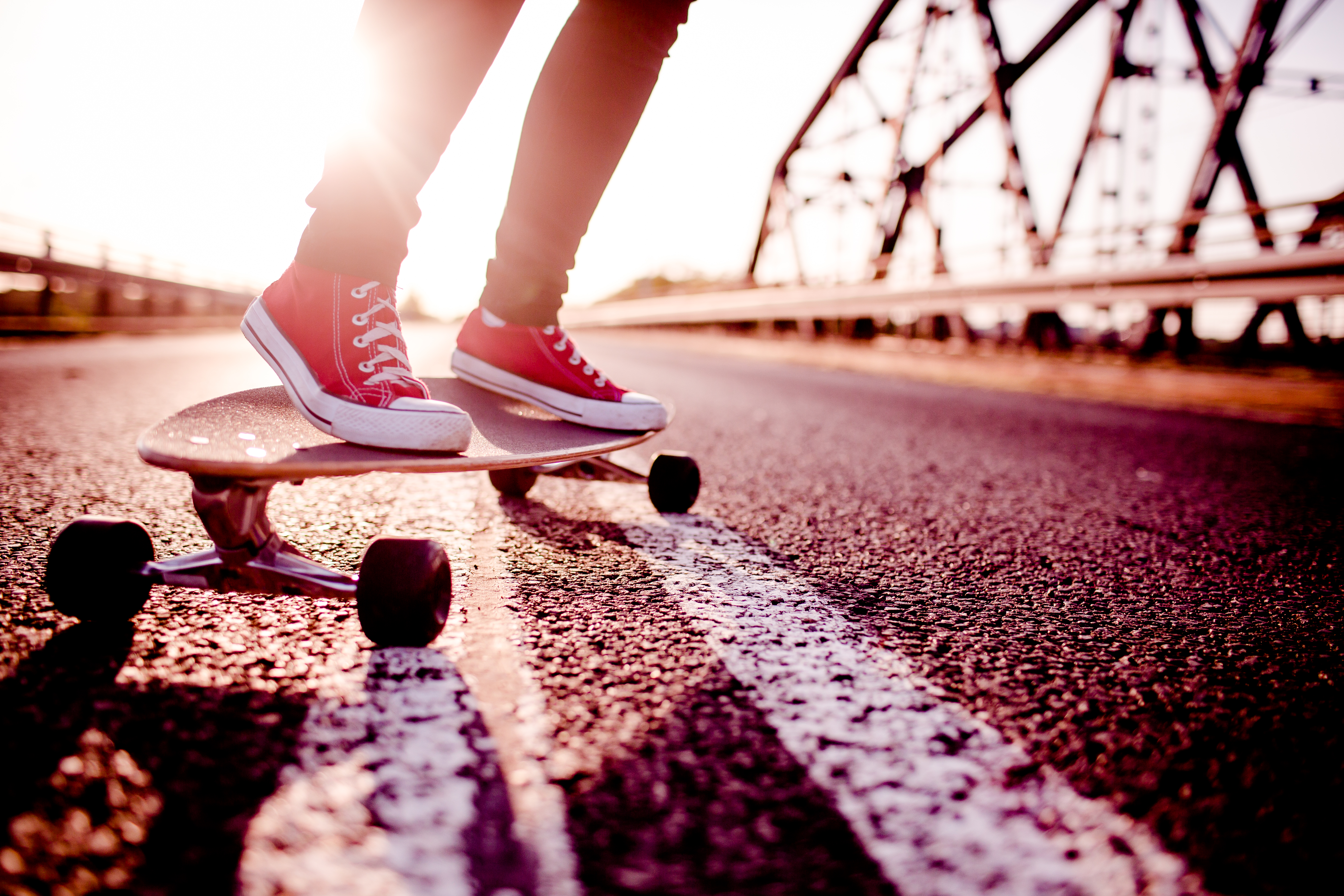 A person in athletic shoes riding a longboard