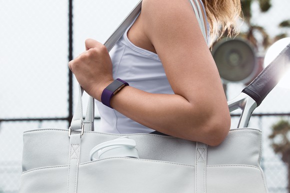 A woman wears a Fitbit Charge 2.