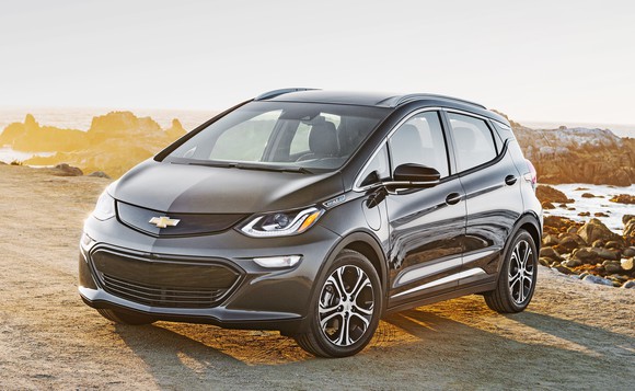 A black 2018 Chevrolet Bolt EV parked on a sunny beach.