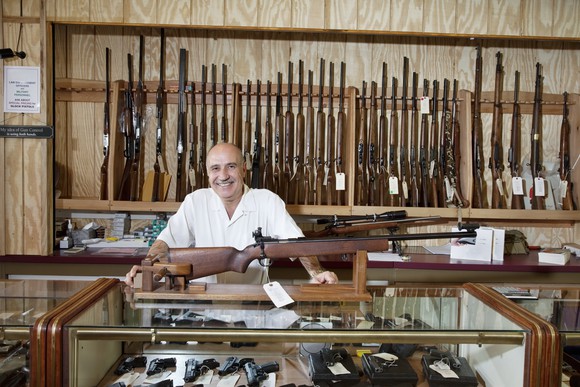 Man in front of a firearms display at a gun store