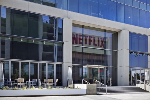 The glass front face of a building with the Netflix logo above the door.