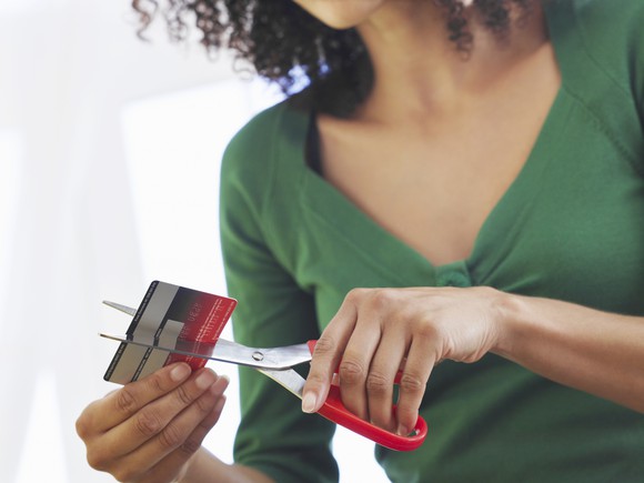 woman cutting credit card in half with scissors