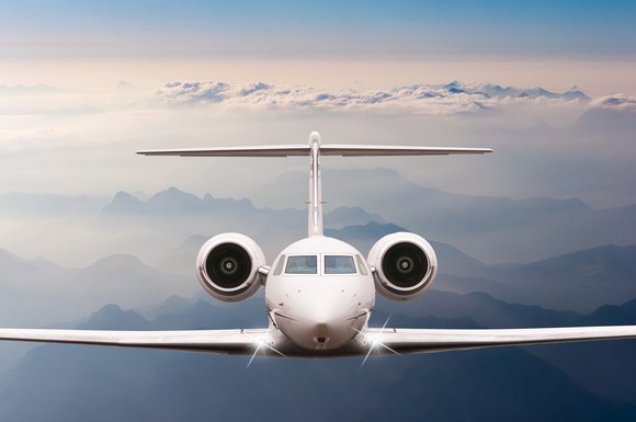 An airplane flying over clouds and mountains.