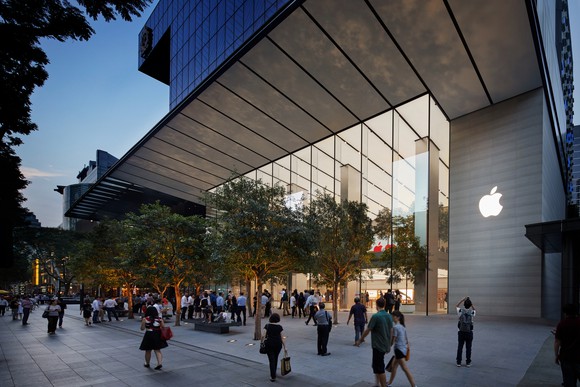 Crowds in front of the Apple store in Singapore at dusk.