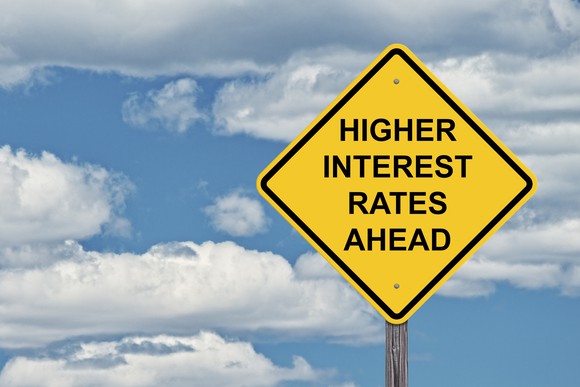 yellow road sign that says higher interest rates ahead