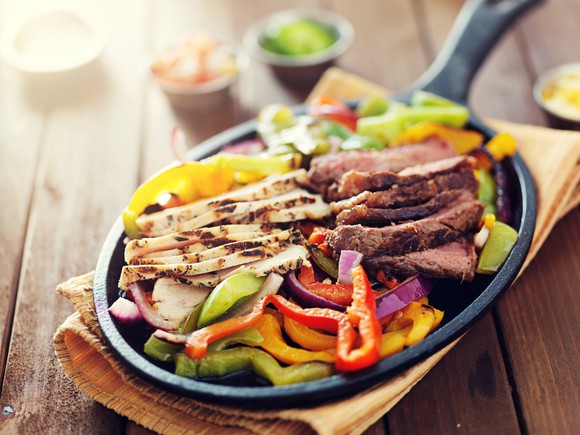 Beef and chicken fajitas, served on a skillet