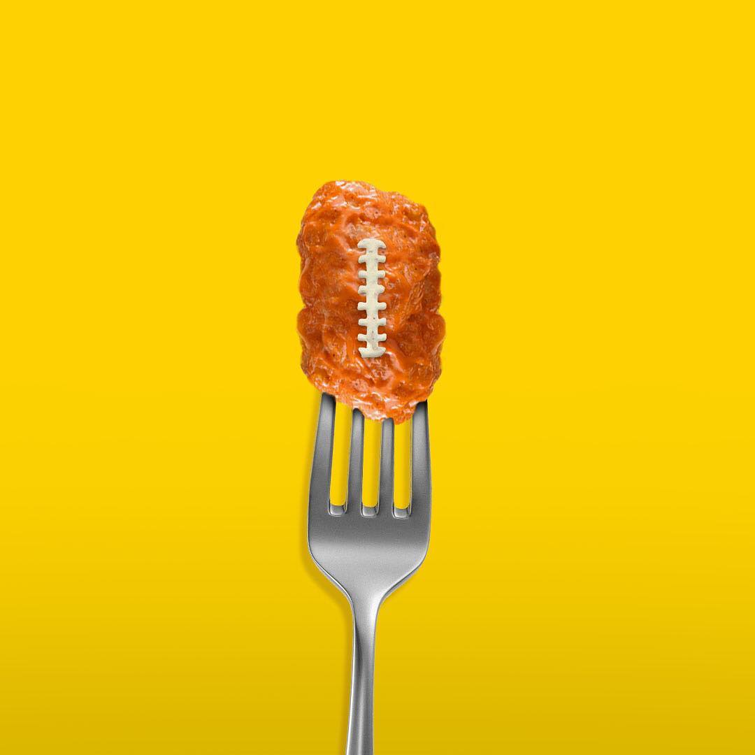 Boneless chicken wing shaped like football on a fork