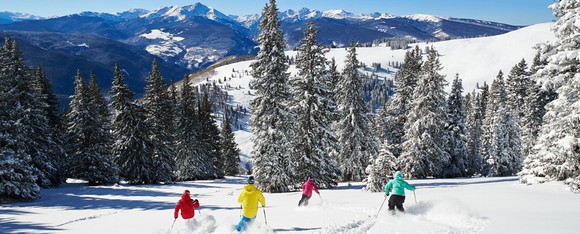 Skiers heading down a mountain at Vail.