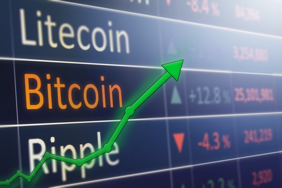 A rising chart overlaid on digital prices for Litecoin, bitcoin, and Ripple.