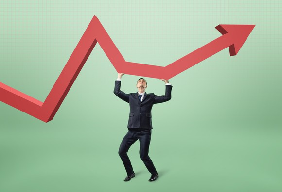 Man holding up red stock price arrow