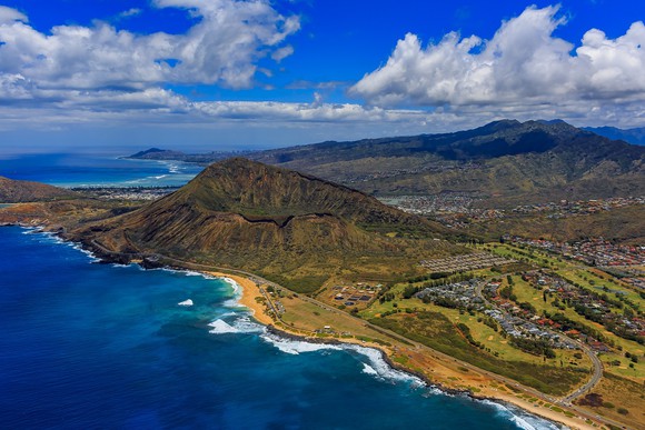 Aerial view of volcano crater near Honolulu, showing land and coastline.
