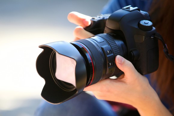 A photographer holding a full-frame camera.