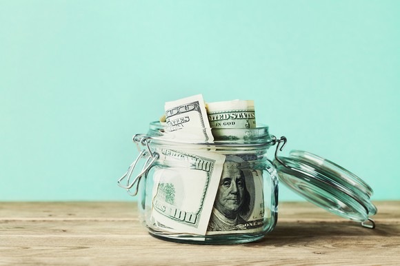 $100 bills in a glass jar
