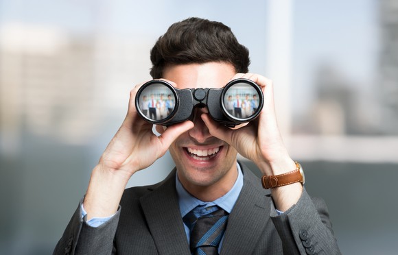 Businessman looking into binoculars.