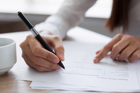 Closeup of woman's hand filling out a job application.