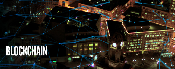 Aerial view of a city at night with blue lines connecting various parts of the image -- concept for blockchain.