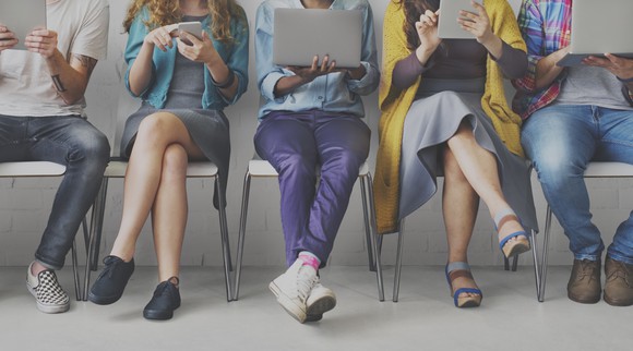 A group of people using mobile electronic devices