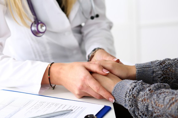 Doctor holding the hands of a patient.