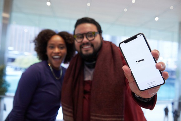 Two people, including an Apple customer holding the iPhone X on launch day