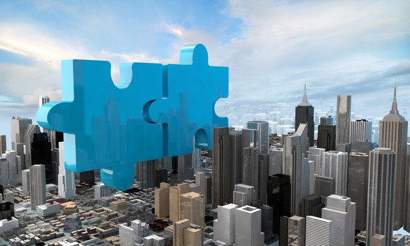 Two giant puzzle pieces placed in a city landscape.