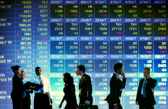 People superimposed on display of stock prices.
