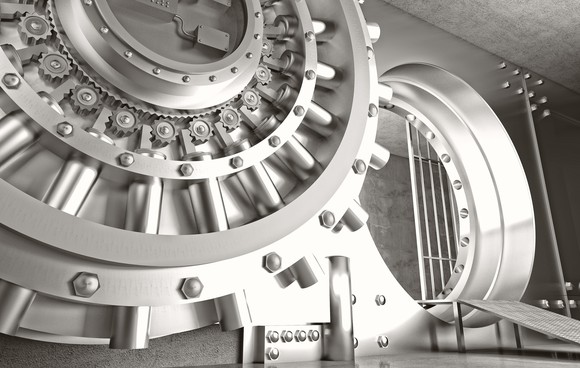 Bank vault with shiny silver round door and small view of inside of vault.