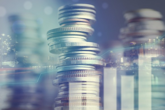 Stacks of coins behind a bar graph.