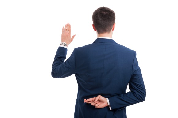 A businessman makes a promise, but crosses his fingers behind his back.