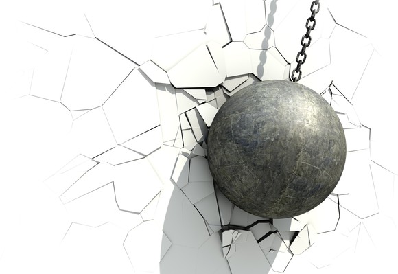 A metallic ball wrecking a white wall
