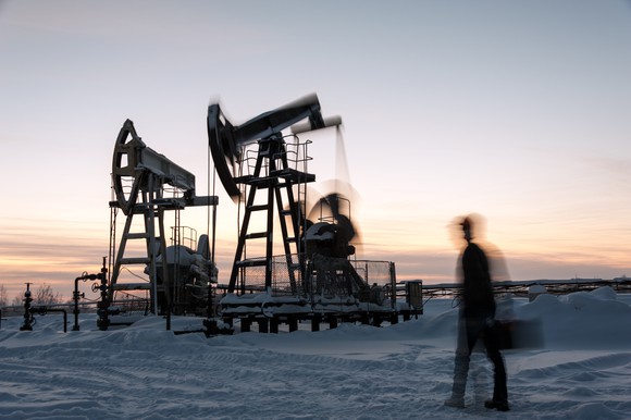 Long exposure shot of rig worker at a pumpjack in winter