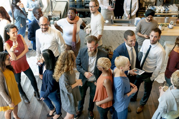 People gather at what looks like a work cocktail party.