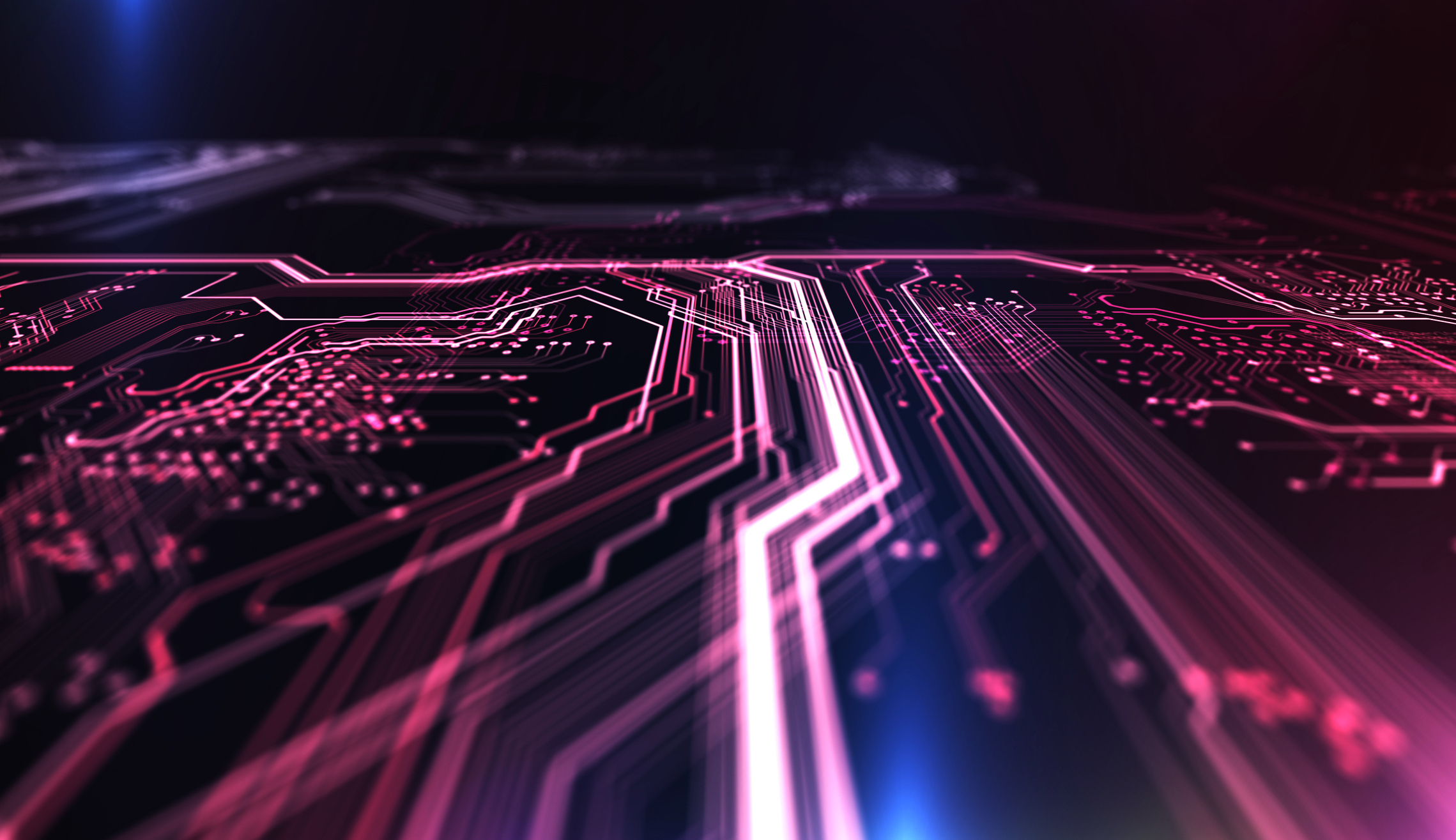 Computer circuit board illuminated in red and blue.