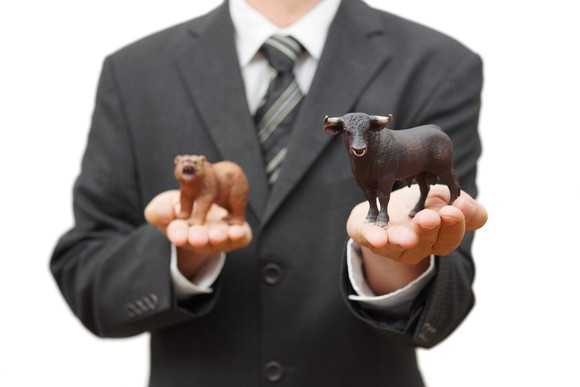 Wall Streeter holding a bull in the foreground and a bear in the background.