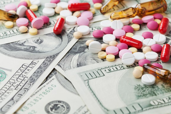 An assortment of colorful medications on top of $100 bills