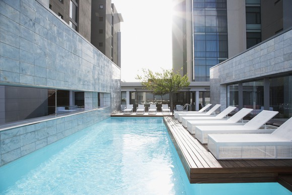 Modern lounge chairs next to swimming pool