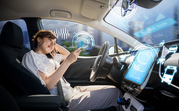 A woman sits in a driverless car.