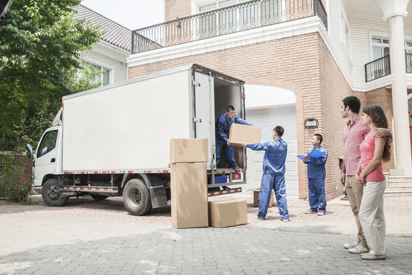 Couple watching as movers load up a van