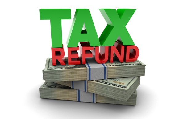 The words tax refund on top of a stack of bills