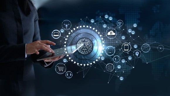 Bubbles with different concepts connected by bright lines, person with ipad in the background.