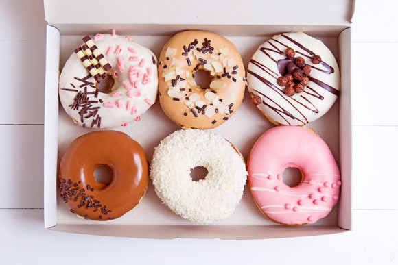 A selection of colorful donuts in a box.
