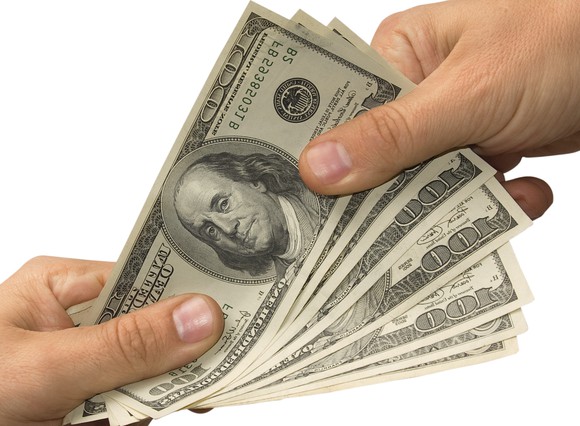 Handing over several hundred dollar bills.
