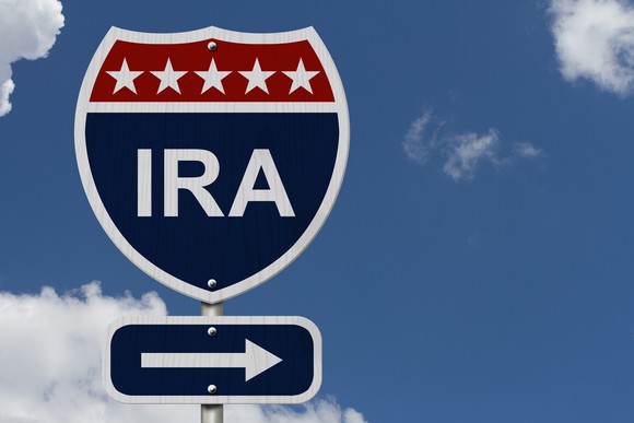 A blue and red road sign, in the shape of an interstate marker, labeled IRA, with an arrow pointing toward the right.