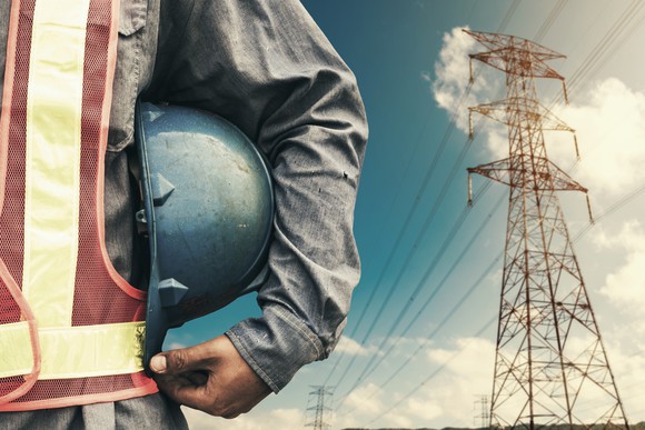 The torso of a standing man with power lines in the background
