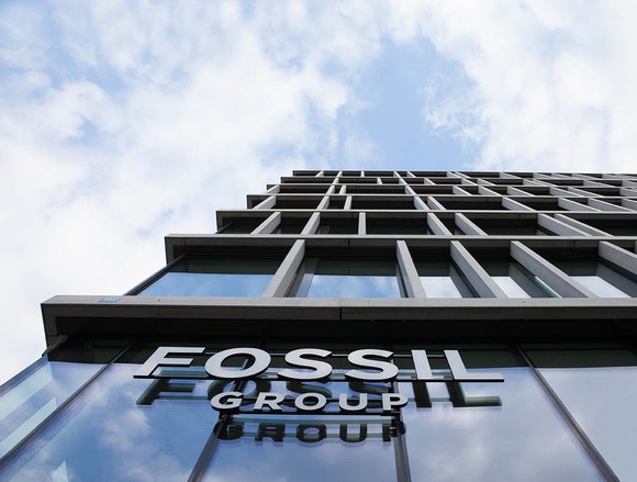 Fossil Group headquarters sign on a tall glass building from below