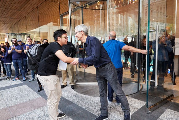 Tim Cook shaking a customer's hand at an Apple Store