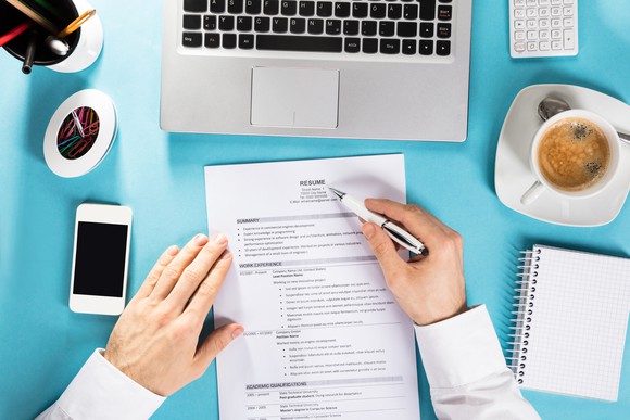 A man takes a pen to a resume.