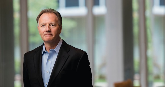 Altria CEO Marty Barrington standing in front of a glass window at the company's headquarters.